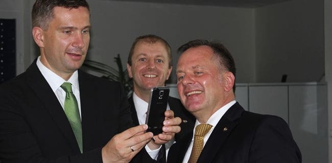N+P Geschäftsführer Jens Hertwig (li.) erläutert Sachsens Wirtschaftsminister Martin Dulig (r.) auf einem Smartphone den Stand von Augmented Reality bei N+P